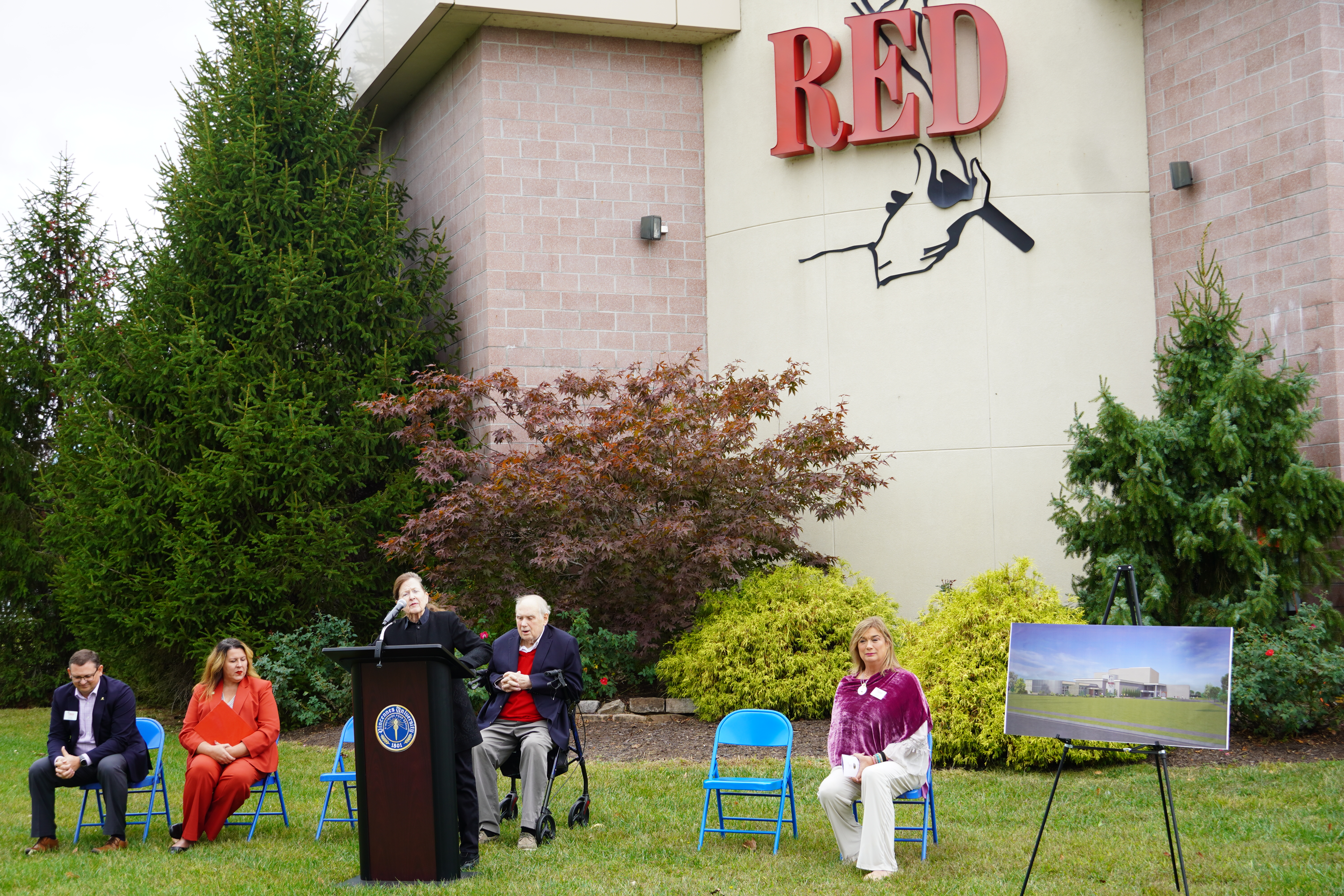 Lothian Skelton stands at podium in front of Red Skelton Performing Arts Center and speaks to the crowd during a ceremonial groundbreaking for the Lothian and Red Skelton Gallery of Fine Art.
