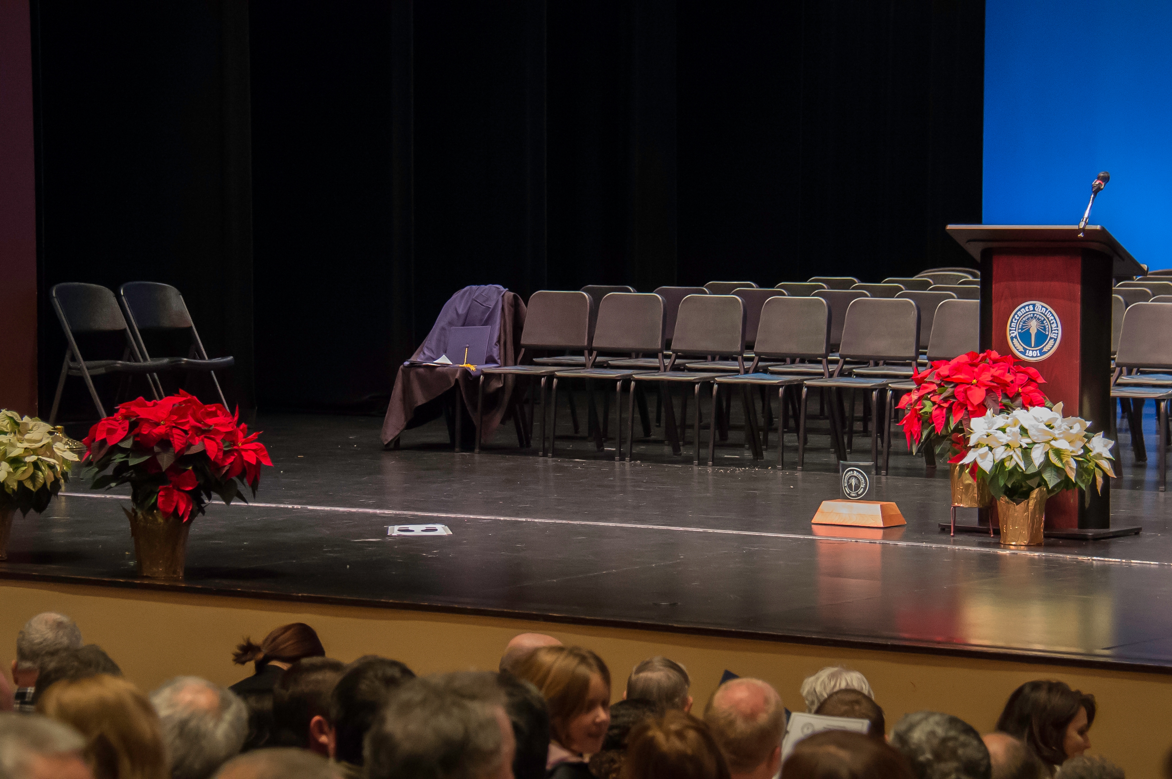 Photo of chairs, degree holder, flowers and podium during Mid-Year Commencement on the Red Skelton Performing Arts Center statge