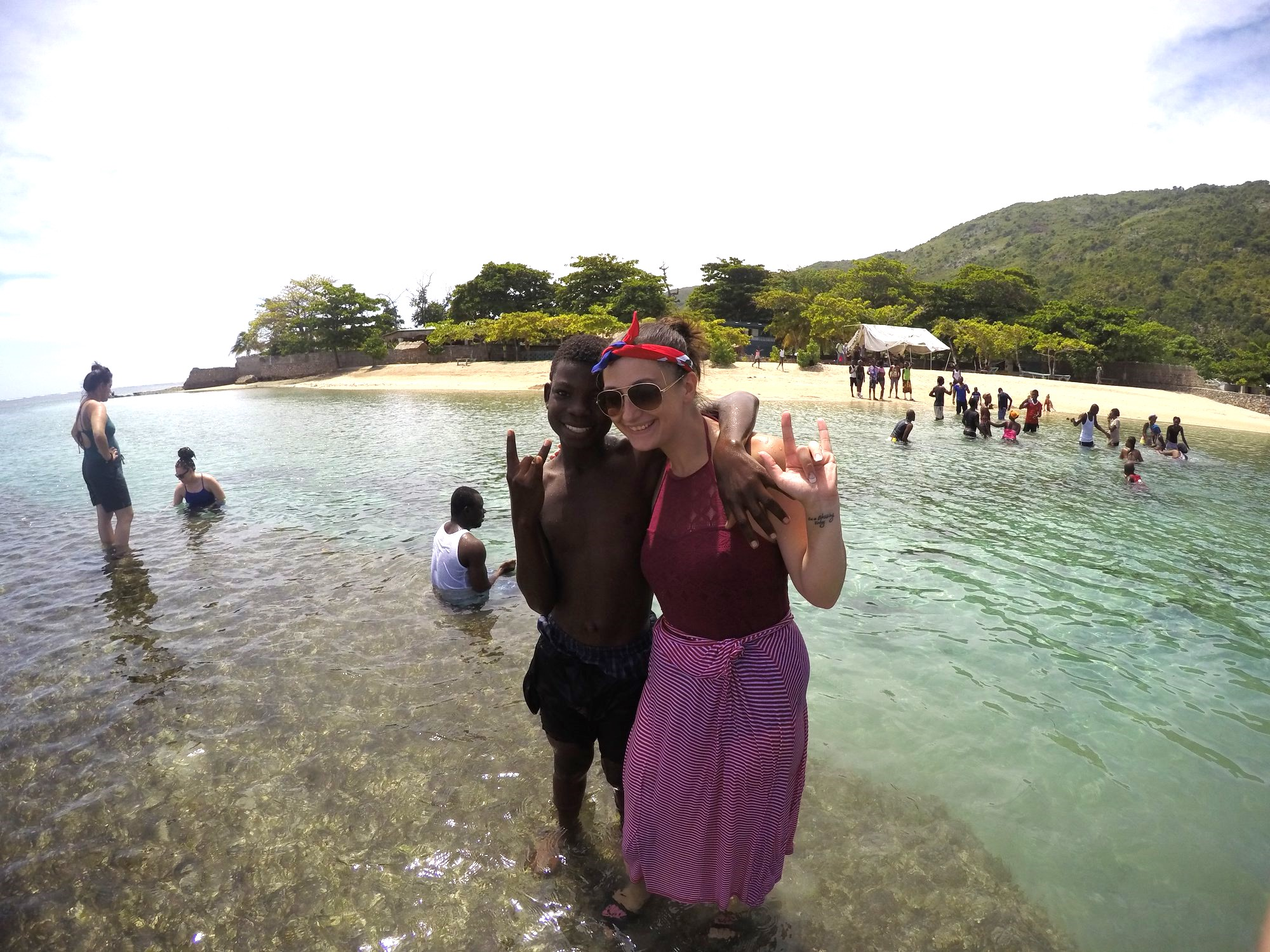 Kara Nicholson standing in the sea with a youth in Haiti